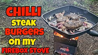 Cooking steak burgers on a firebox stove - cooking steak burgers with cheese & onions.