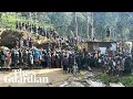 People in papua new guinea dig through mud and debris after huge landslide