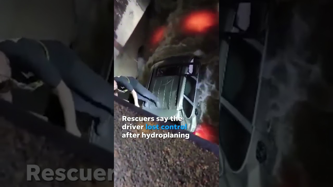 Driver rescued from hood of car after crashing into floodwaters #Shorts