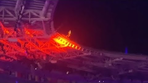 Tom Cruise abseils from roof of Stade de France then rides off on motorbike at the Olympics