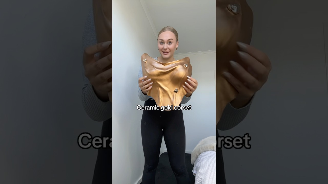 A size 14 try’s on the viral gold resin corset 