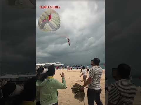 A woman managed to land safely after being blown mid-air with her parasail thanks to Good Samaritans