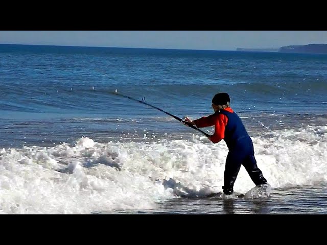 Pesca en la playa con mar azul y sol brillante en el cielo azul y