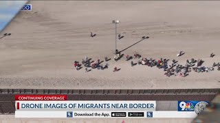 Aerial footage shows migrants waiting, lining up along border