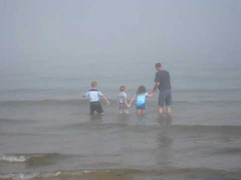 Kids jumping waves in the fog of Lake Michigan