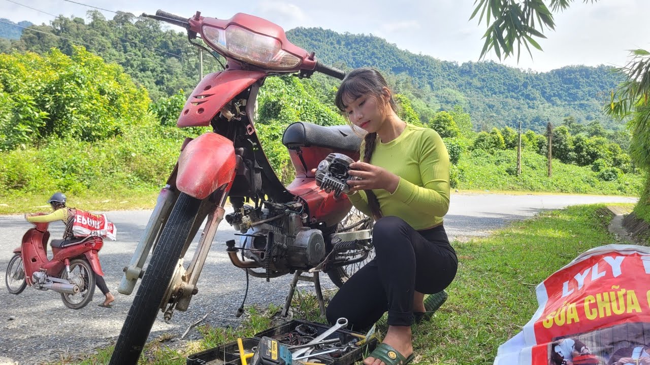Girl fixes broken motorbike engine on the roadside