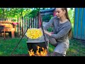 Une fille ukrainienne cuisine du bortsch vert ukrainien dans le village travaux de jardinage
