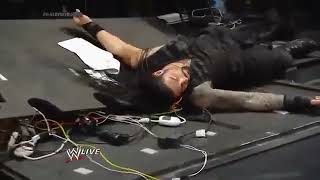 Batista powerbombs Roman Reigns through table