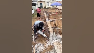 What a Worker Demolishes Old Concrete Foundation on Site with an Electric Hammer, Dust