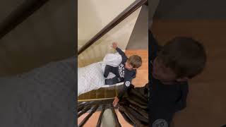 Boy rides laundry basket down stairs in house in the falls forward midway and faceplants on carpet