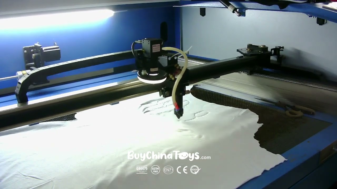 Automatic laser cutting machine cutting plush fabric panels at the toy factory