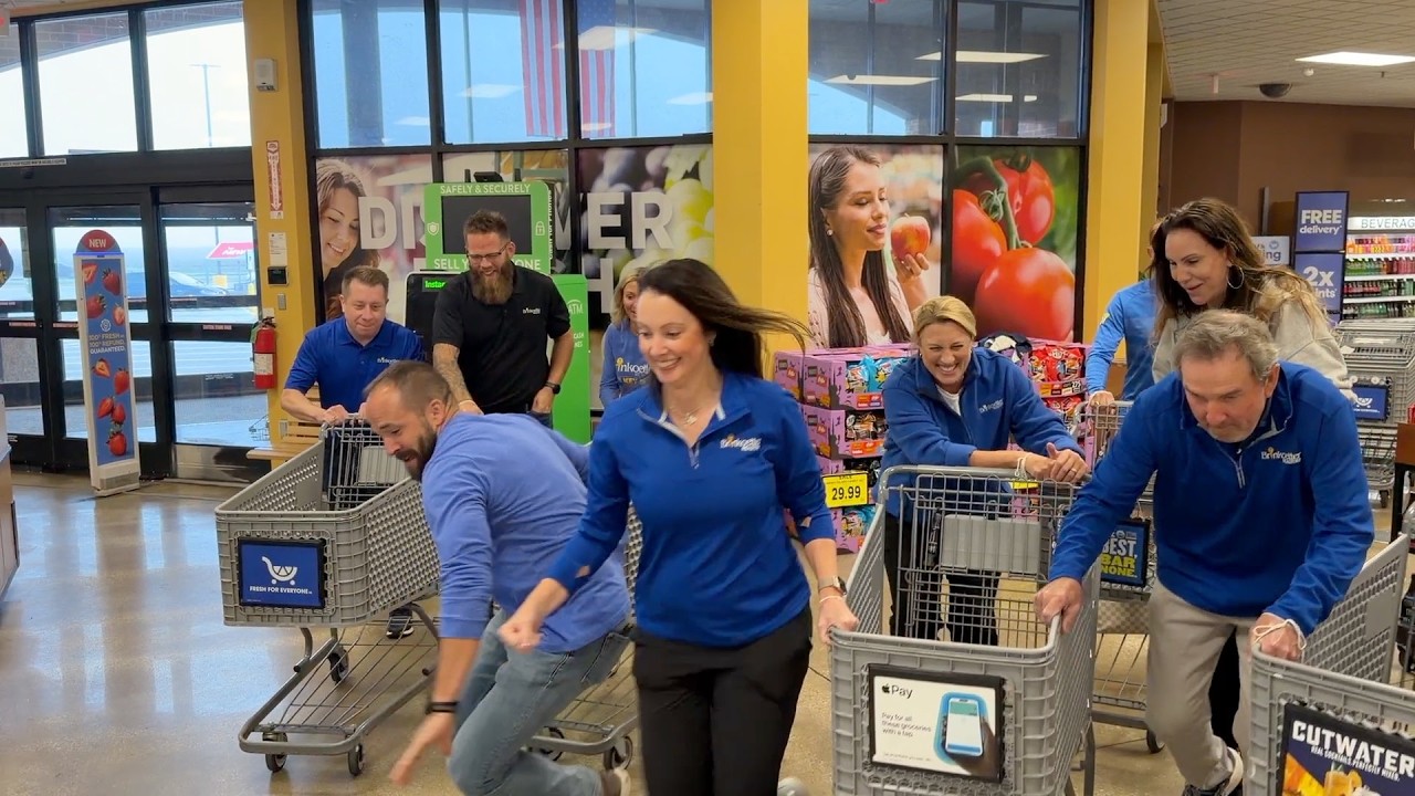 Group of people racing in a store with shopping carts
