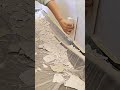 scraping and leveling excess dry wall compound from the interior wall surface with flat plastic tool