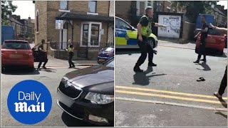 Shocking moment driver appears to knock officer to the ground