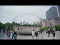 Handheld scene of people visiting Cloud Gate, famously known as The Bean, reflecting Chicago's