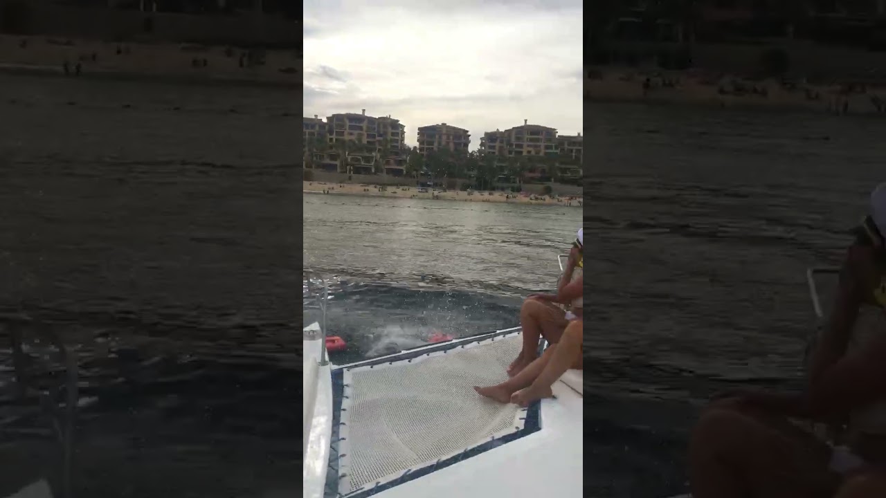 Two girls jump off boat into water but one girl slips and hits her leg