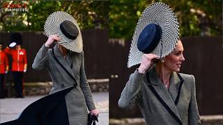 Princess Kate struggling with the wind to keep it from blowing her hat away