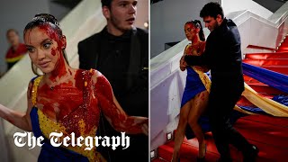 video: Anti-war protester covers herself in fake blood on Cannes red carpet