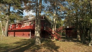 Red barn house surrounded by water.