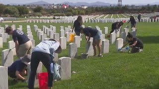 Volunteers clean gravestones at Miramar National Cemetery