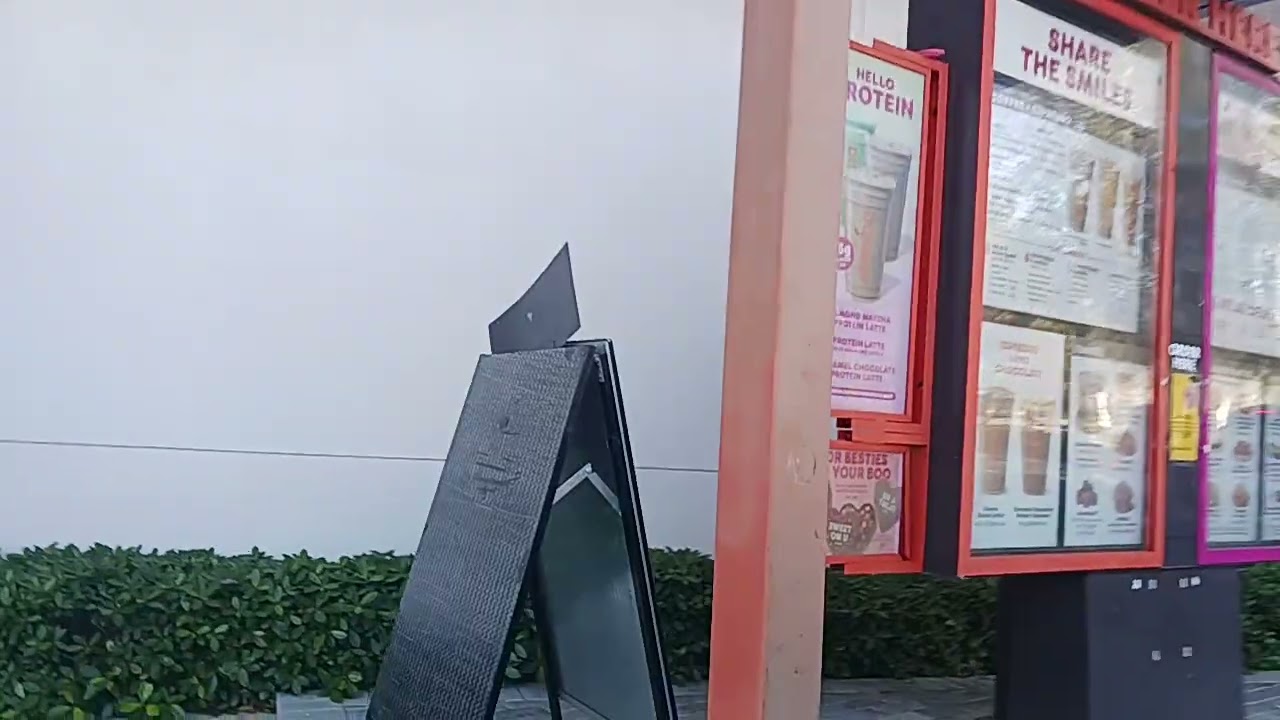 Лео делает заказ в окошке автокафе Dunkin Donuts.