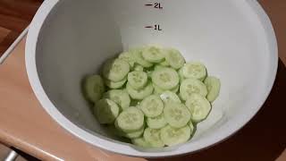 Zubereitung Eines Salates Aus Gurke Und Tomaten Mit Salatkräuter.