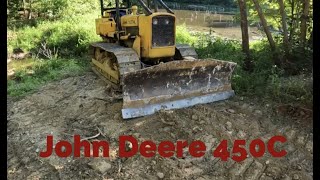 John Deere 450c pushes hard clay and concrete slab