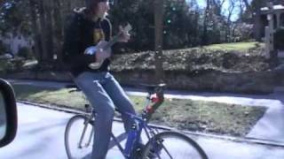 Guy riding bike backwards w ukalele