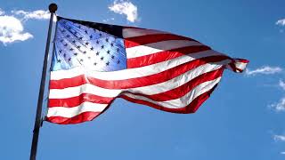 Free Stock Video - American Flag waving against a blue sky with sun glowing from behind