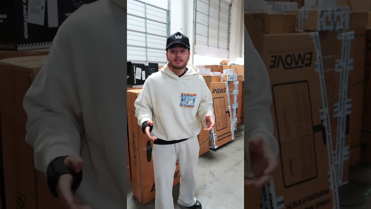 A VoroMotors rep in the warehouse among boxed EMOVE scooters