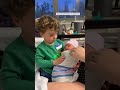 Toddler confused by newborn sister wrapped in a swaddle