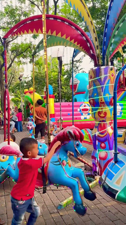 Upin rides the merry-go-round, the red-haired pony