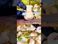 peeling a fresh green coconut using a sharp metal knife to reveal the white flesh during the day