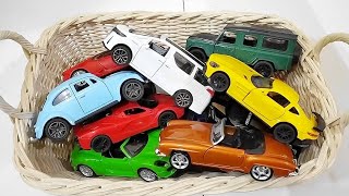 Box full of various miniature cars Toyota Vellfire, Land Rover Defender, Range Rover, Maybach 43