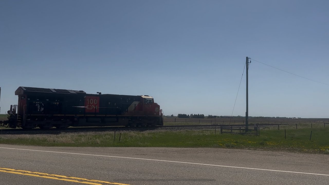 CN 100 unit with safety inspection boxcar rolling down the Three Hills sub heading to Calgary