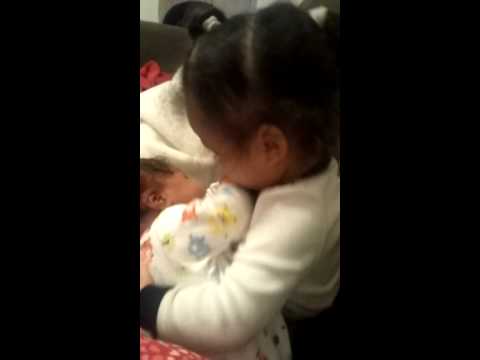 Breastfeeding her baby sister and tells her no bit