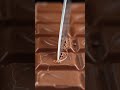 Ultra-realistic ASMR video of a giant milk chocolate bar being sliced with a sharp knife.