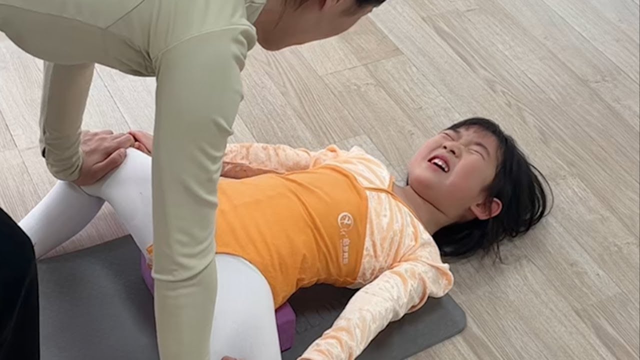 先生たちは、彼女たちのダンスの柔軟性トレーニングをサポートしている。 今日の努力は明日の成功のために。