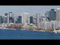 Turboprop plane landing at Billy Bishop Toronto City Airport flying past downtown high rise