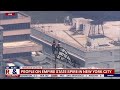 Couple flies banner atop Empire State Building spire