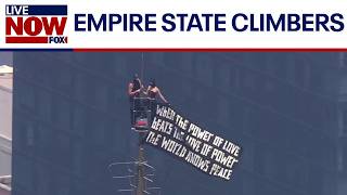 Couple flies banner atop Empire State Building spire