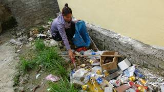 The poor girl collects empty plastic cans and bottles to sell for money