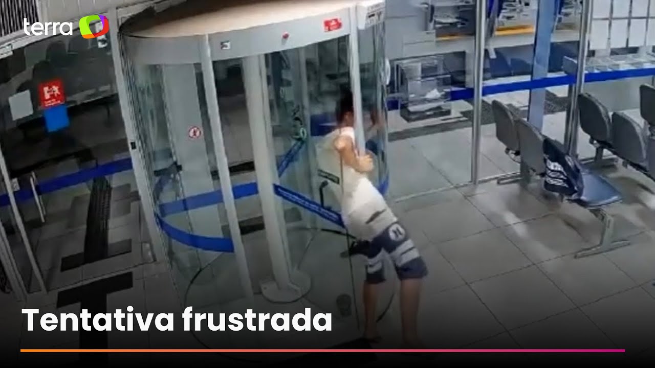 Ladrão invade banco, entala em porta giratória e é preso em MG