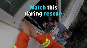 See how firefighters save this old man hanging from a window