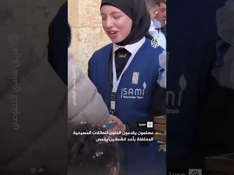 سوريون يقدمون الحلوى للعائلات المسيحية المحتفلة بأحد الشعانين بحمص