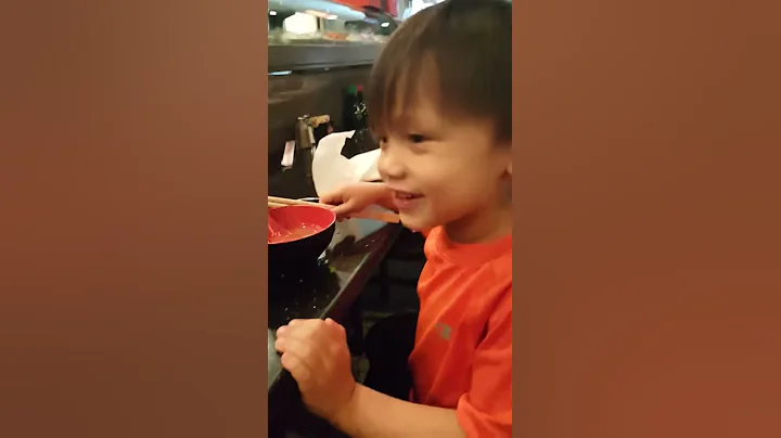 Guy using chopsticks to spoon his miso.