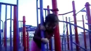 Girl falls on park pole and looks surprised
