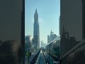 A train traveling through a city with tall buildings#dubai #travel🇦🇪