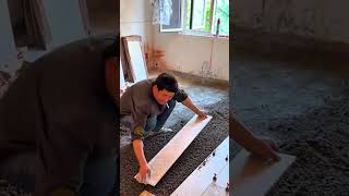 Installing ceramic tiles on the floor using cement and leveling tools to ensure a flat even surface