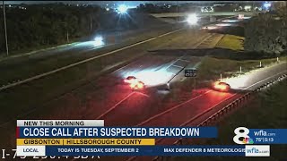 Close Call on Florida Highway: Car Speeds Between Man and Broken-Down Vehicle